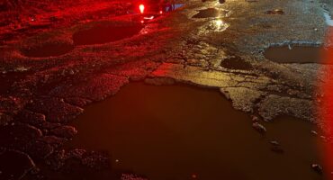 Accident scene with the focus being water filled potholes