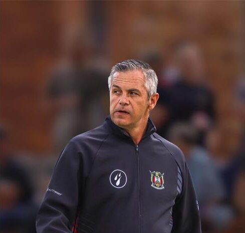 Grey haired man wearing a black jacket