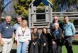 Group of people standing next to or sitting on a jungle gym
