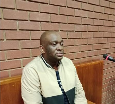 Black man staring out in front of him while sitting in a court's witness stand