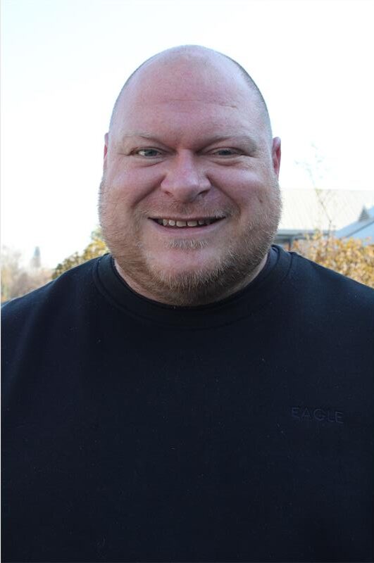White man smiling at the camera