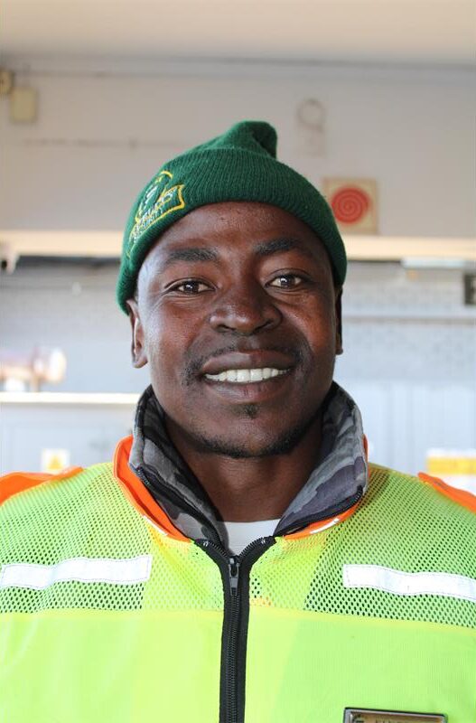 Black man wearing a green beanie and reflective jacket