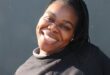 Black woman smiles as she makes a playful pose