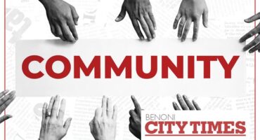 A black and white and red image of hands of various shades reaching in towards each other and the word community.