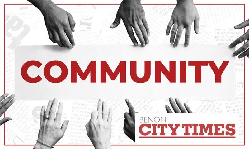 A black and white and red image of hands of various shades reaching in towards each other and the word community.