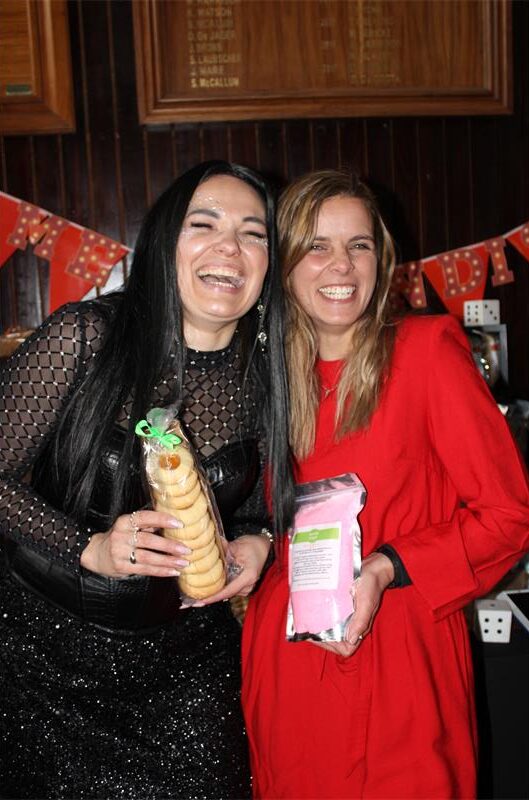 Two white women laughing while holding biscuits and bath salts