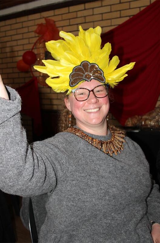 White woman with glasses wearing a feathered headrest