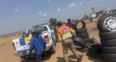 EMPD officer carrying a tyre to a marked EMPD vehicle