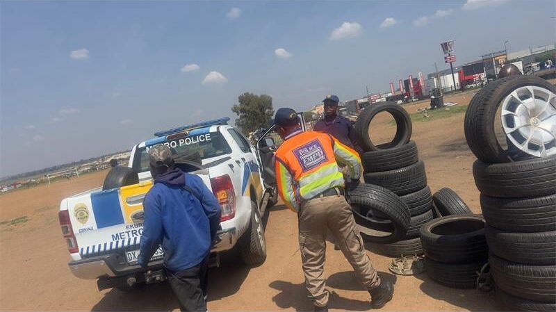 EMPD officer carrying a tyre to a marked EMPD vehicle
