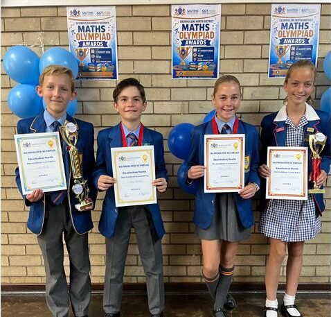 Four children, two boys and two girls holding certificates