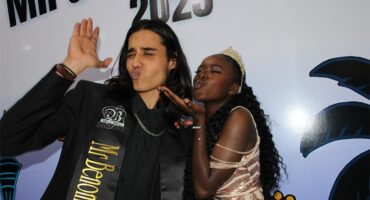 Indian man an black lady in formal attire blowing kisses