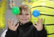 Boy smiling while throwing balls into the air