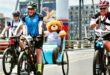 Cyclist with a teddy bear on the back of a bike, taking part in a race.
