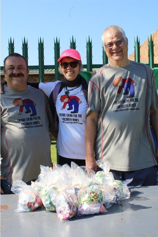 Two men and a woman smiling at the camera