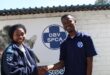 Black man wearing an SPCA shirt shakes hands with a black woman wearing an SPCA inspector's jacket