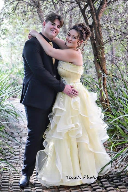 Young man and girl hold each other wearing evening wear