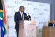 Black man standing at a podium addressing an audience