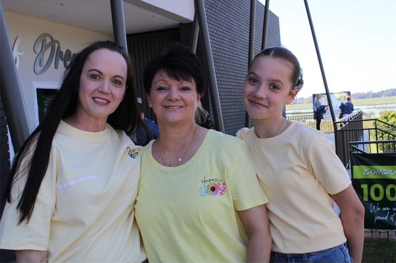 Three women wearing yellow