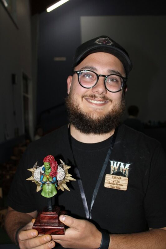Man wearing glasses holding a statue
