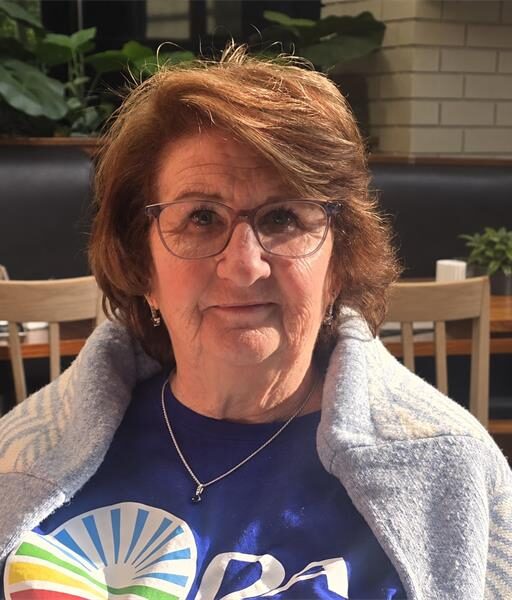 Elderly white woman with glasses wearing a DA shirt