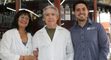 Woman holds and older man's arm with a young man standing next to them