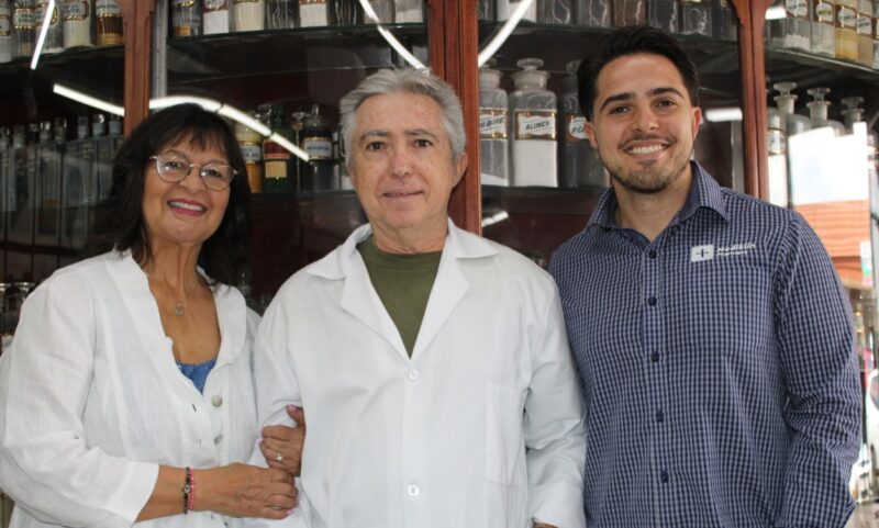 Woman holds and older man's arm with a young man standing next to them