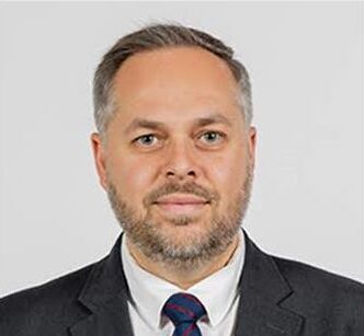 A man in a black suit and a blue tie.