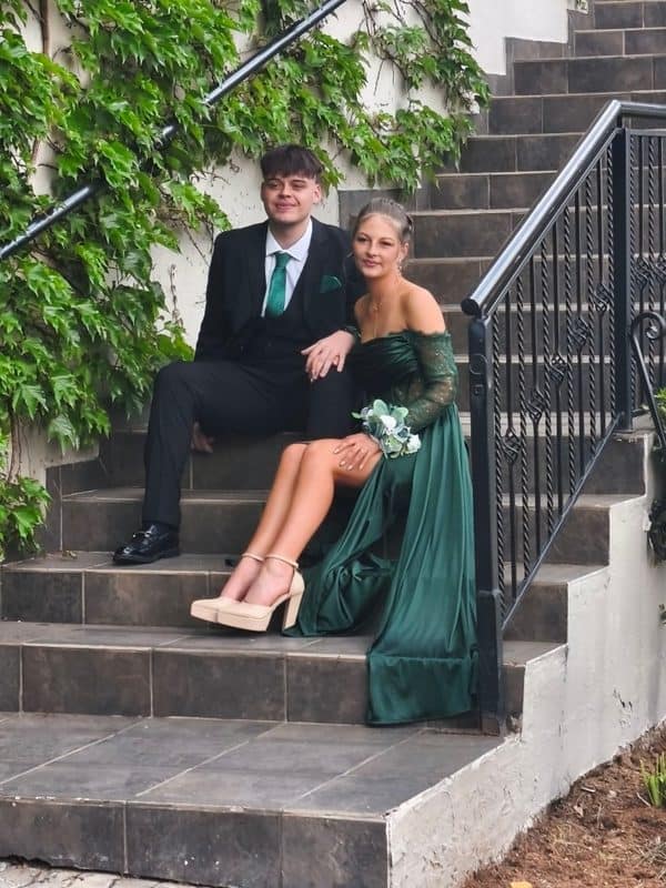 Boy and girl wearing evening wear sitting on a staircase