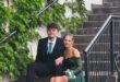 Boy and girl wearing evening wear sitting on a staircase