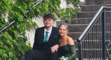 Boy and girl wearing evening wear sitting on a staircase