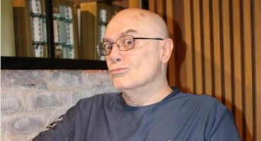 Elderly man wearing glasees poses making a duck face