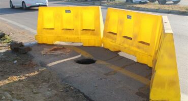 Yellow plastic cordons around a hole in the ground