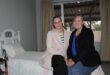 Two white women sitting on a bed