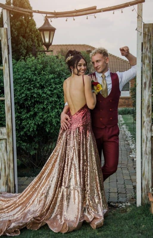 Young man and girl wearing evening wear holding each other