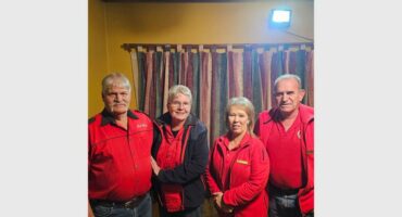 Three people in red shirts standing next to each other.
