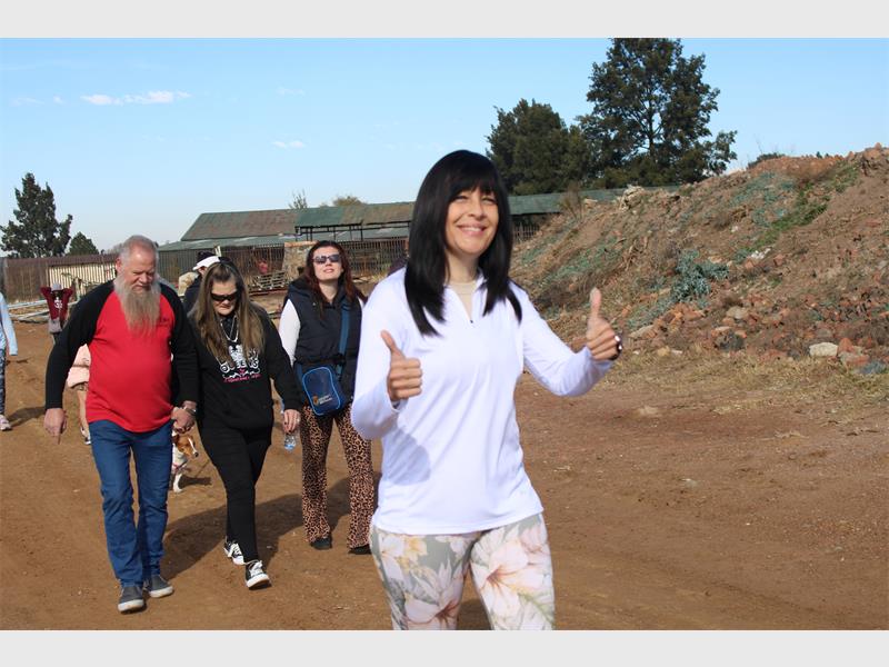 A woman giving the thumbs up while walking with other people.