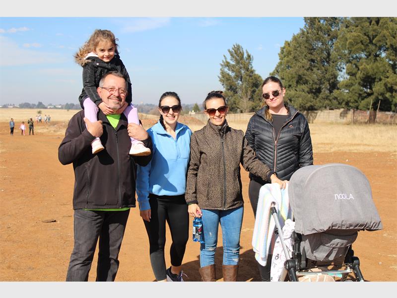 A family poses for a photo in the dirt.