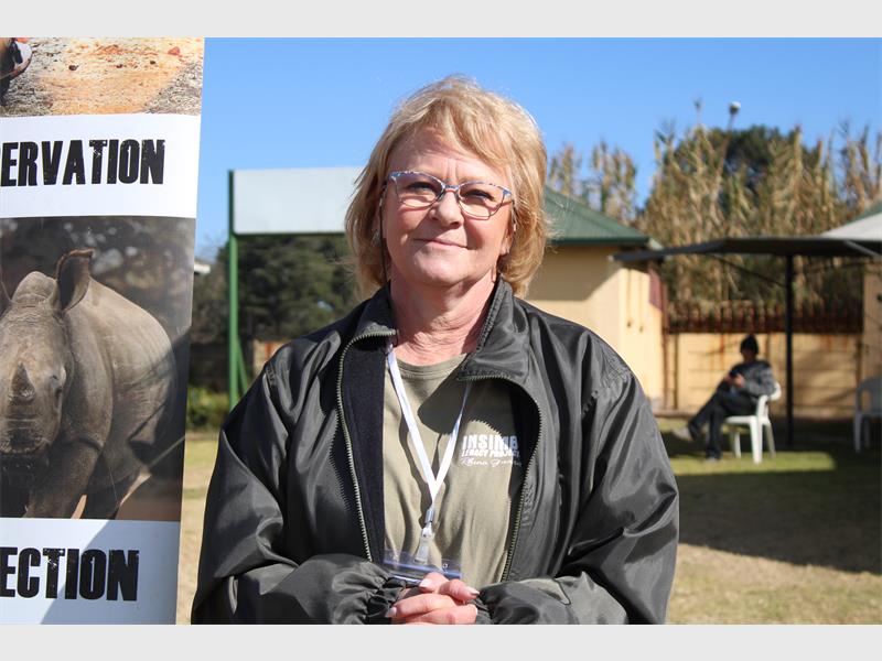 A woman standing next to a sign that says conservation.