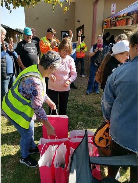 People in safety vests and vests are standing around a pink bag.