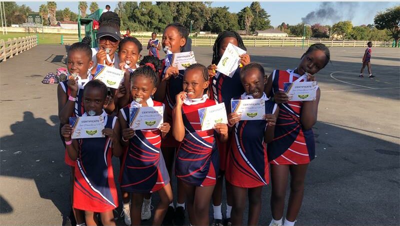 A group of young girls holding up their certificates.