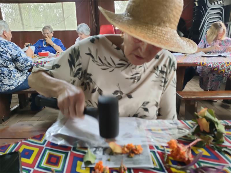 Die lede het by hul maandelikse byeenkoms geleer hoe om vars blomme op kaartjies te druk.