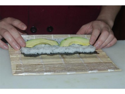 The sushi before it is rolled inside a bamboo mat.