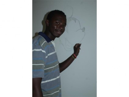 Siyabonga Thanjekwayo with the rough outline of one of the artworks he is busy painting on the walls at the Springs court. This is done at the the office of the state prosecutor, Leanie Hattingh, who is working with abused children.