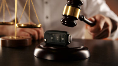 Close up of judge gavel and car keys over soundboard on white