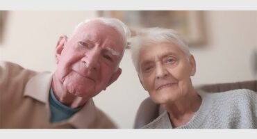 An older couple is taking a selfie together.