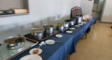 A long table with many dishes and bowls on it.