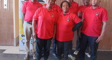A group of people in red shirts posing for a photo.