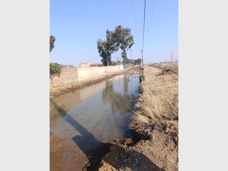 Community members say poor road conditions caused by a burst water pipeline hampered emergency access during a house fire, prompting calls for greater accountability.
