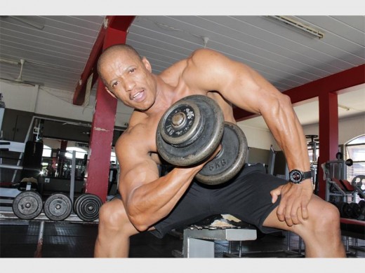 Thabo Pulumo working his biceps with a free-weight concentration curl.