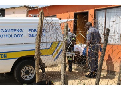 Members of the Germiston Forensic and Pathology Unit remove the victim’s body from the crime-scene.
